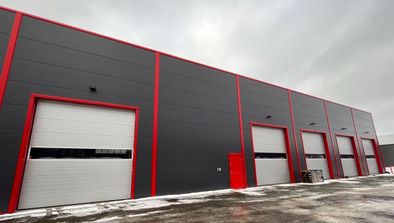 Stor grå hall med garasjeporter med røde detaljer